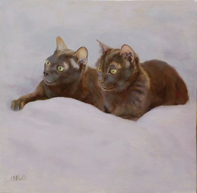 A portrait of two cats lying on a white sheet