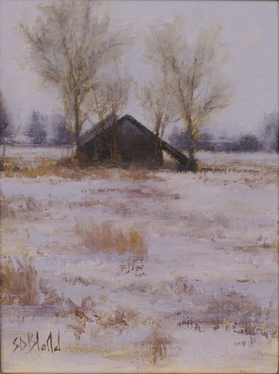 A small dark barn in a snowy landscape with dry grasses and bare trees.