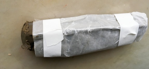 A photo of a home-made oil paint stick wrapped in paper