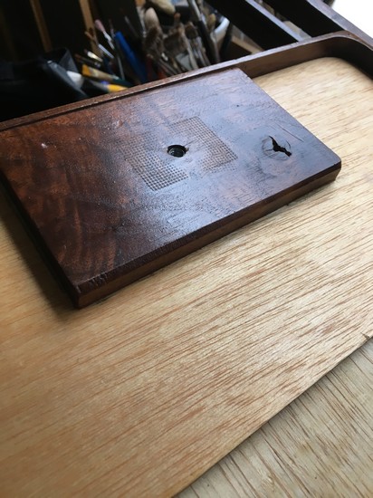 A wood support on the bottom of a pochade box houses a t-nut to which a quick release mounting plate is attached