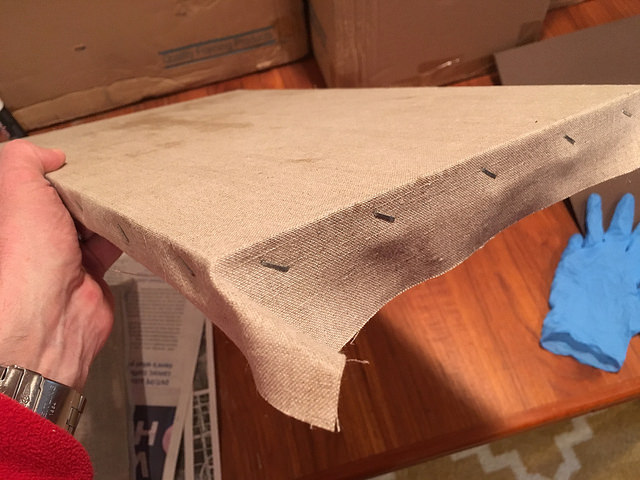 Stapling linen to keep it attached to a painting panel