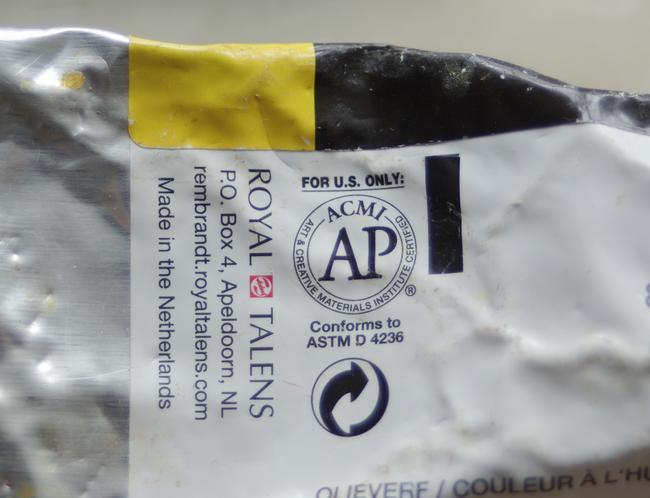 An ACMI AP label on a tube of yellow paint